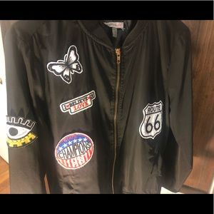 Black bomber jacket with various patterns on it